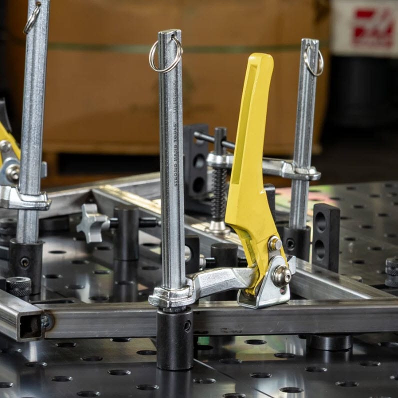 BuildPro welding table clamp with yellow handle securing metal square tubing