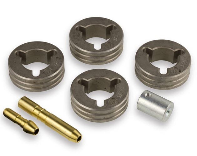 Set of three metal drive rolls and two brass welding tips with a small metal spacer