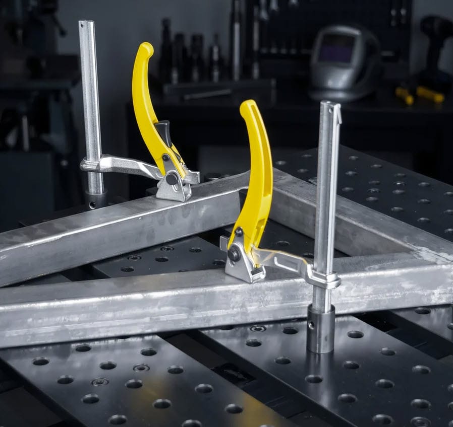 BuildPro lever clamps securing metal square tubing on a welding table