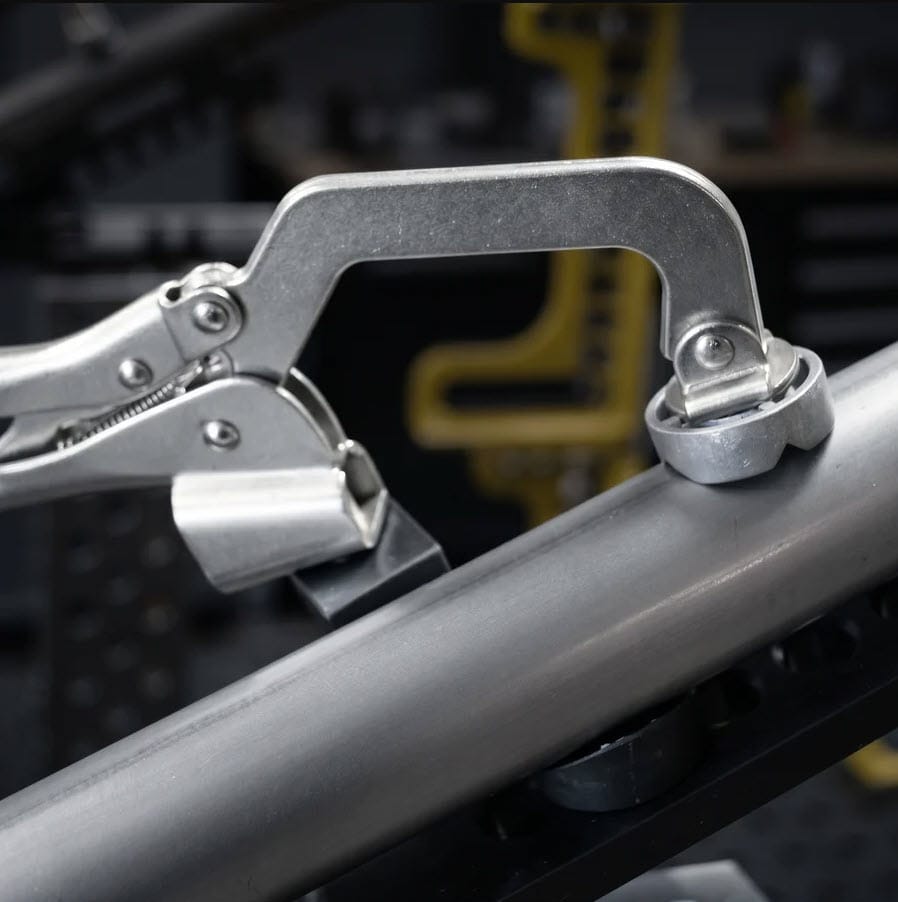 BuildPro locking C-clamp securing a metal pipe to a workbench