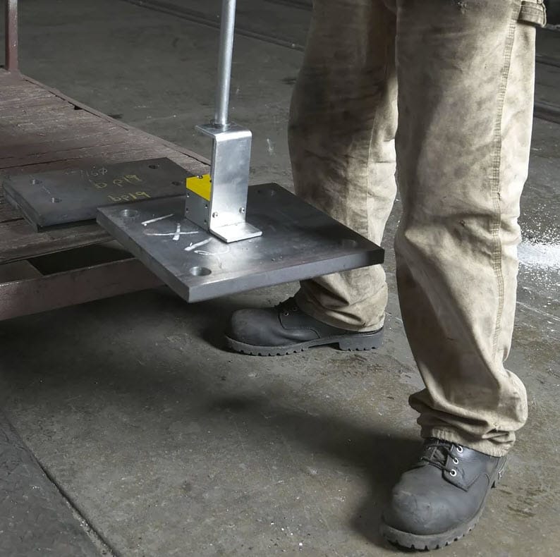 Worker using a Magswitch magnetic lifter to lift a heavy steel plate