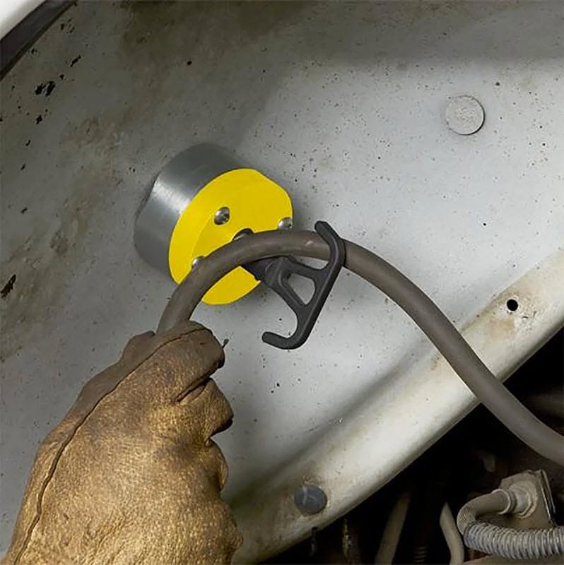 Magswitch magnetic cable hook attached to a metal surface holding a cable