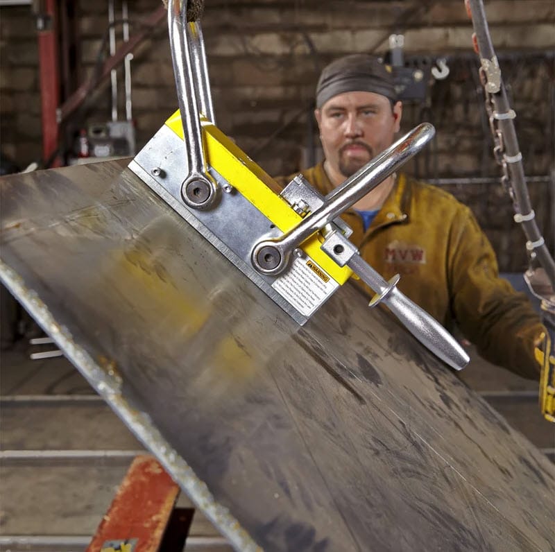 Worker using a Magswitch magnetic lifter to lift a steel plate