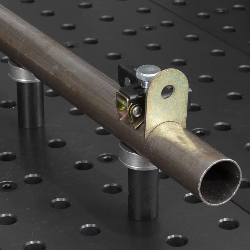 Strong Hand metal pipe clamp secured on a perforated welding table
