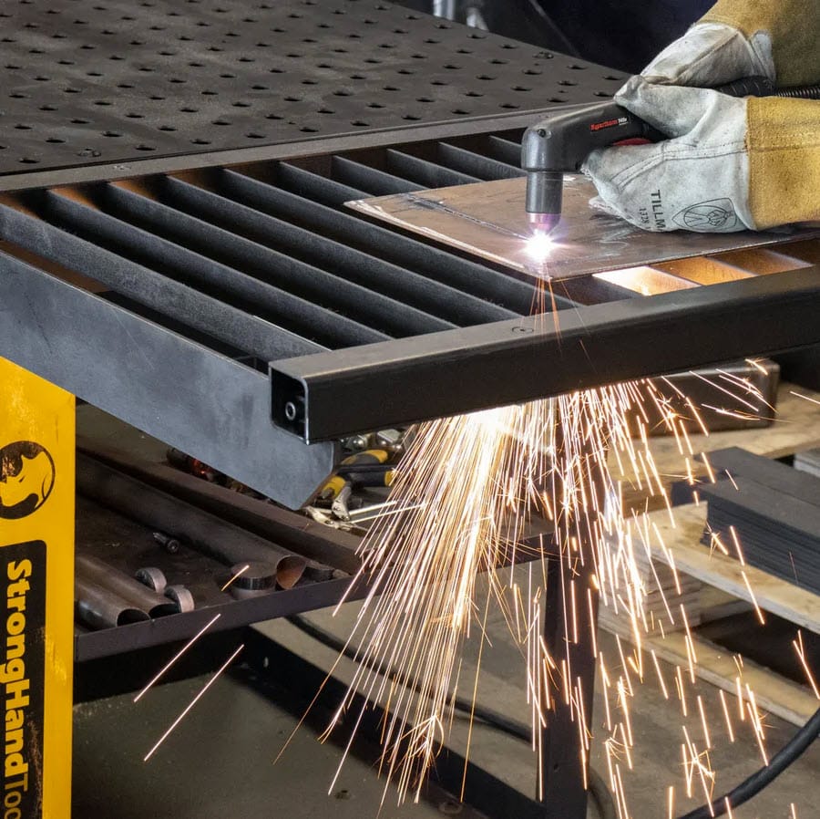 BuildPro welding table with plasma cutter creating sparks on metal plate
